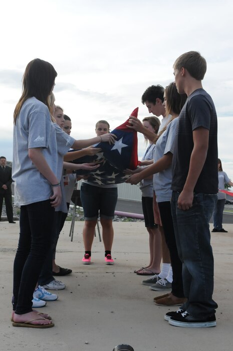 Delegates unfold the flag during a flag retirement ceremony during Freedom Academy at Camp Williams.  High school students from across the state get the opportunity to spend a week learning about freedoms and opportunities they have. (U.S. Army photo by Private 1st Class Ariel J. Solomon)