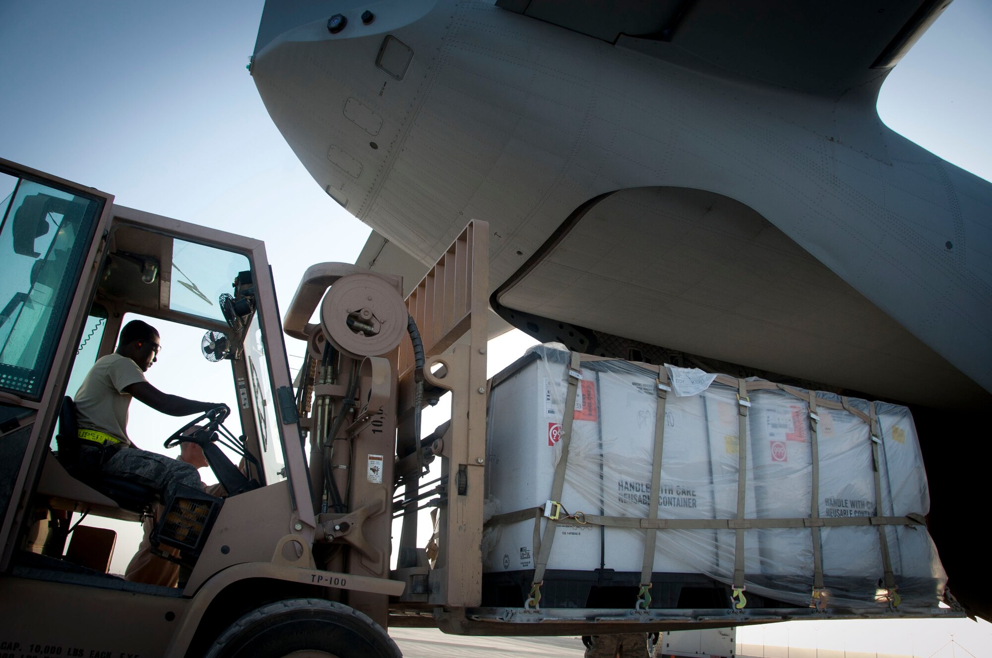 Senior Airman Theophilus Okrah, 451st Expeditionary Logistics Readiness Squadron ramp services member, loads cargo into a C-27 at Kandahar Air Field, Afghanistan, Aug. 3, 2011. The C-27s belong to the 702 Air Expeditionary Squadron.(U.S. Air Force photo by Senior Airman Corey Hook)