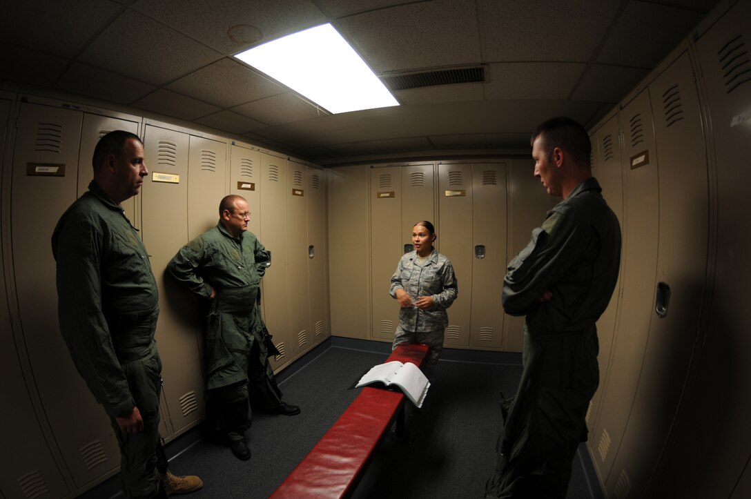 While deployed to Joint Base Elmendorf-Richardson, Alaska, SSgt Jennifer Rodriguez, Air Flight Equipment (AFE) briefs incentive flight riders on the egress hanging harness. (U.S. Air Force Photo by: Technical Sergeant, Anthony M. Mutti)