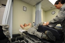 KUNSAN AIR BASE, Republic of Korea -- Staff Sgt. Carrie Merced, 8th Medical Operations Squadron, physical medical technician, applies ice to a patient's ankle at their physical therapy session here on Aug. 4. She sees patients daily assisting them with the exercises to help strengthen and improve mobility to area of a patient's injury. (U.S. Air Force photo by Staff Sgt. Rasheen Douglas/Released)
