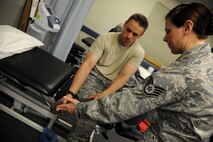 KUNSAN AIR BASE, Republic of Korea -- Staff Sgt. Carrie Merced, 8th Medical Operations Squadron, physical medical technician, checks for swelling and tenderness of a patient's ankle during a physical therapy session here on Aug. 4. She sees patients daily assisting them with the exercises to help strengthen and improve mobility to area of a patient's injury. (U.S. Air Force photo by Staff Sgt. Rasheen Douglas/Released)