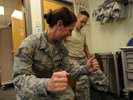 KUNSAN AIR BASE, Republic of Korea -- Staff Sgt. Carrie Merced, 8th Medical Operations Squadron, physical medical technician, demonstrates the motion for the exercise with an excersice ball during a physical therapy session here on Aug. 4.  She sees patients daily assisting them with the exercises to help strengthen and improve mobility to area of patient's injury. (U.S. Air Force photo by Staff Sgt. Rasheen Douglas/Released)