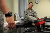 KUNSAN AIR BASE, Republic of Korea -- Staff Sgt. Carrie Merced, 8th Medical Operations Squadron, physical medical technician, demonstrates stretching exercises using a stretch band to a patient during a physical therapy session here on Aug. 4. She sees patients daily assisting them with the exercises to help strengthen and improve mobility to area of patient's injury. (U.S. Air Force photo by Staff Sgt. Rasheen Douglas/Released)