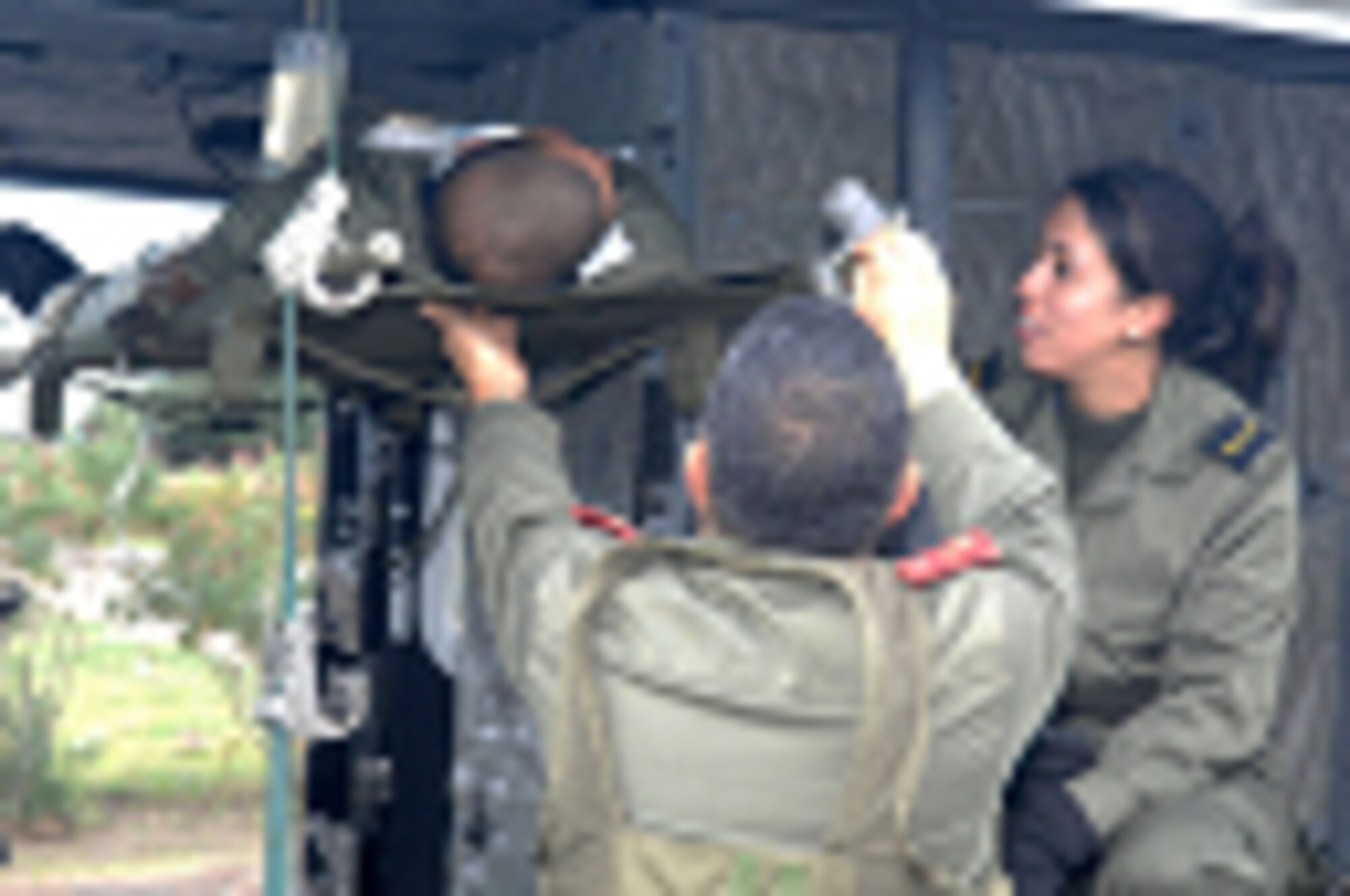 Members of the Tunisian Army, Major Hassib Ammar, left, an aeromedical physician, and Sergeant Sabrine Dhari, right, an aeromedical emergency care nurse, secure a litter patient onboard a UH-1 B model Iroquois helicopter for evacuation after a simulated chemical plant explosion during Medlite 2008, at Kharrouba Air Base, Tunisia, Nov. 17, 2008. Medlite 2008 is a joint nations medical training exercise between U.S. Air Force and Army medical personnel and the Tunisian Army. (U.S. Air Force photo by Senior Master Sgt. Kim Allain)