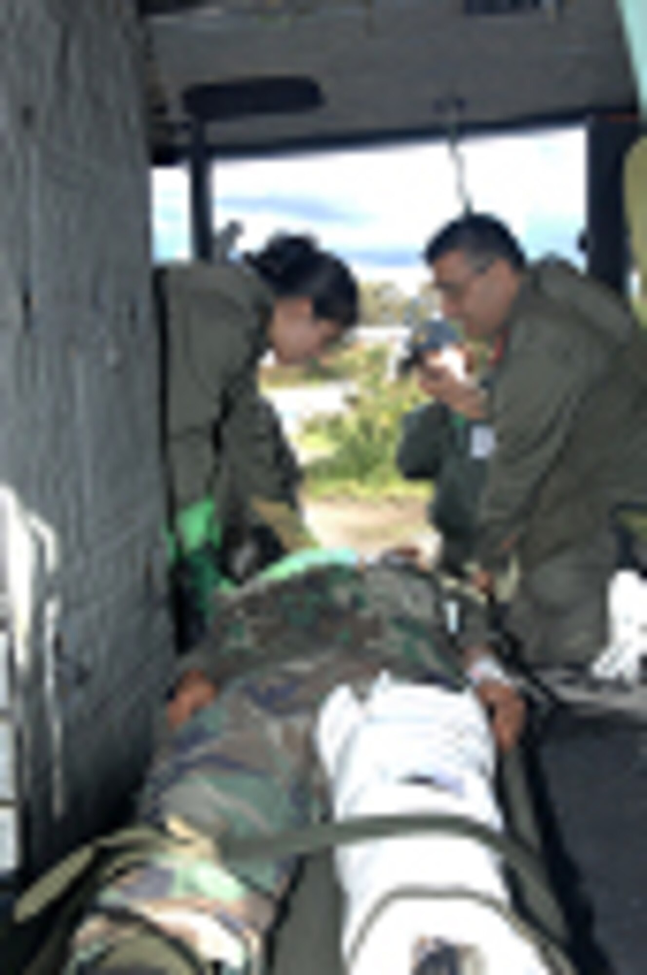 Members of the Tunisian Army, Sergeant Sabrine Dhari, left, an aeromedical emergency care nurse, and Major Hassib Ammar, right, an aeromedical physician, load a patient litter onboard a UH-1 B model Iroquois helicopter for evacuation to the hospital after a simulated chemical plant explosion during Medlite 2008, at Kharrouba Air Base, Tunisia, Nov. 17, 2008. Medlite 2008 is a joint nations medical training exercise between U.S. Air Force and Army medical personnel and the Tunisian Army. (U.S. Air Force photo by Senior Master Sgt. Kim Allain)