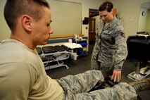 KUNSAN AIR BASE, Republic of Korea -- Staff Sgt. Carrie Merced, 8th Medical Operations Squadron, physical medical technician, takes a look at a patient's ankle during a physical therapy session here on Aug. 4. She sees patients daily assisting them with the exercises to help strengthen and improve mobility to area of a patient's injury. (U.S. Air Force photo by Staff Sgt. Rasheen Douglas/Released)