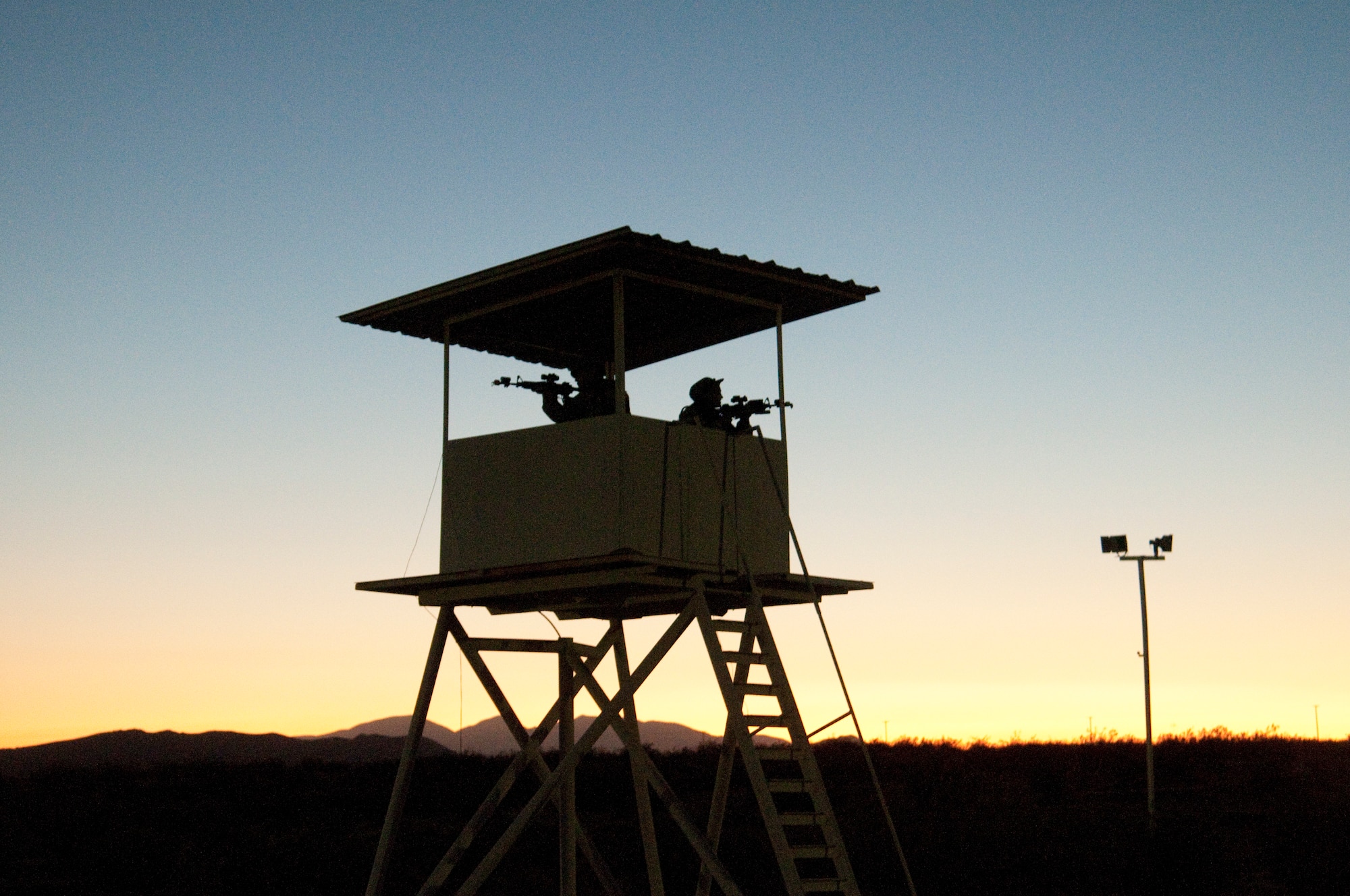 Members of the 144th Security Forces Squadron stand guard in a observation tower while taking part in a field training exercise at Camp Corum, Edwards Air Force Base, Calif. on Aug 4, 2011.  The Security Forces Squadron exercised at a training site deep into the Mojave Desert for the five day engagement which focused on night operations. (U.S. Air Force photo by MSgt. David J. Loeffler)