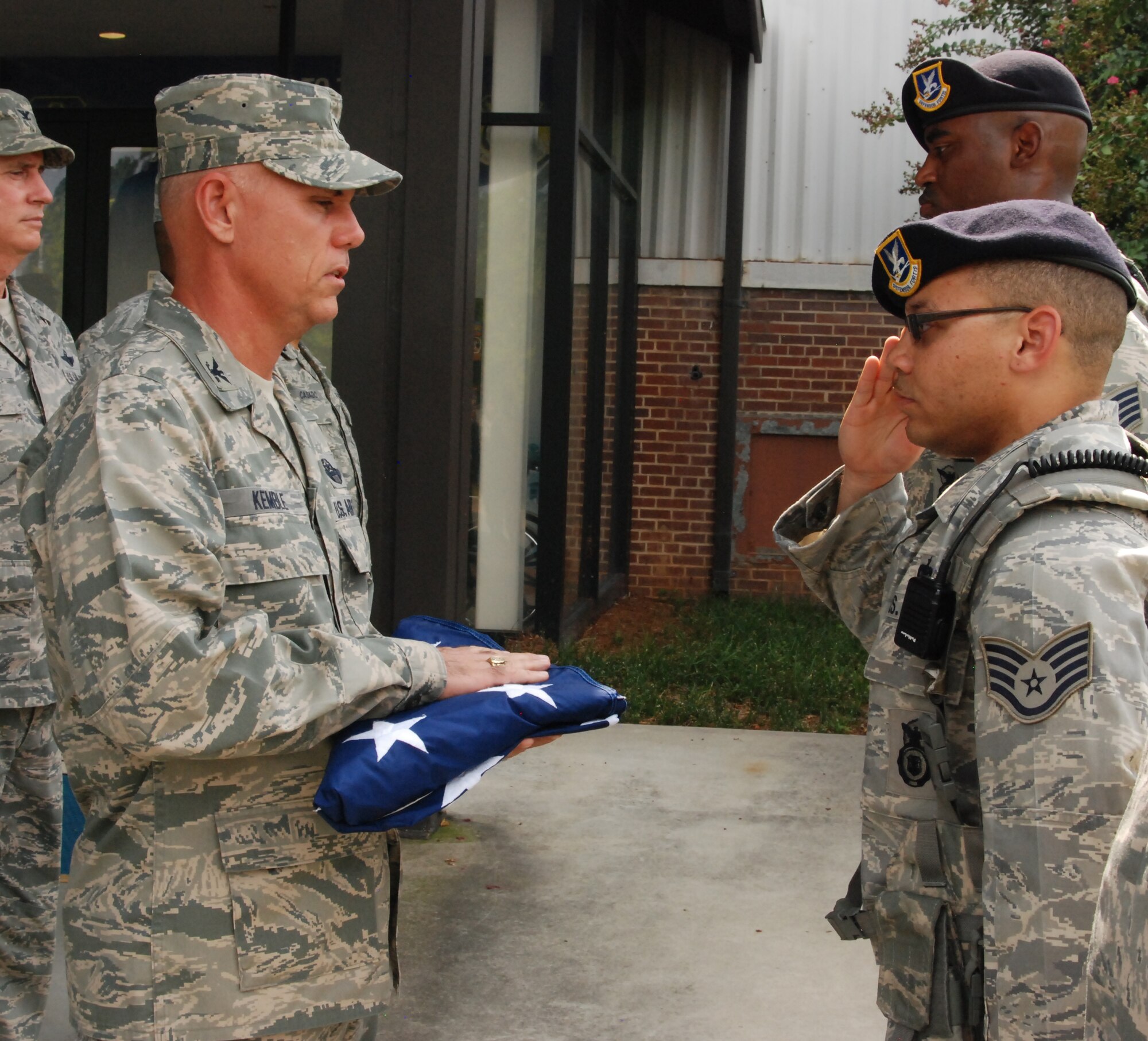 Staff Sgt. Devontay Williams salutes Col. Richard Kemble, 94th Airlift Wing vice commander, after presenting him the flag. Williams, along with other members of the detail, position themselves three paces away from the vice commander to hand him the flag. Once the vice commander returns the salute the detail marches away and waits for dismissal. (U.S. Air Force photo/Airman 1st Class Chelsea Smith). 
