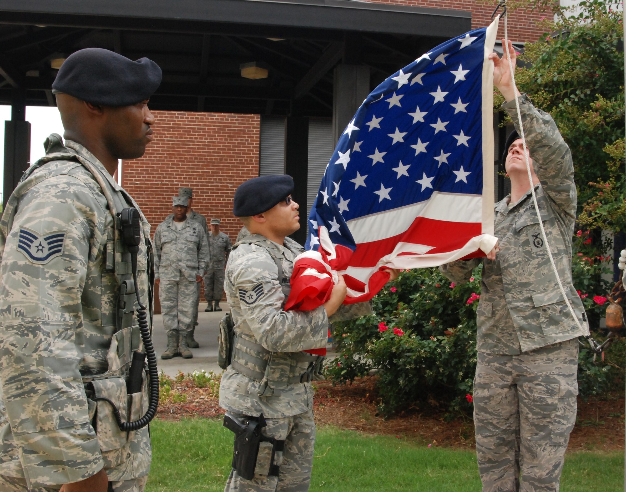 Staff Sgt. Devontay Williams, 94th Airlift Wing security forces responder and detail commander of the four-member team,  retrieves the flag in preparation for folding. (U.S. Air Force photo/Airman 1st Class Chelsea Smith)
