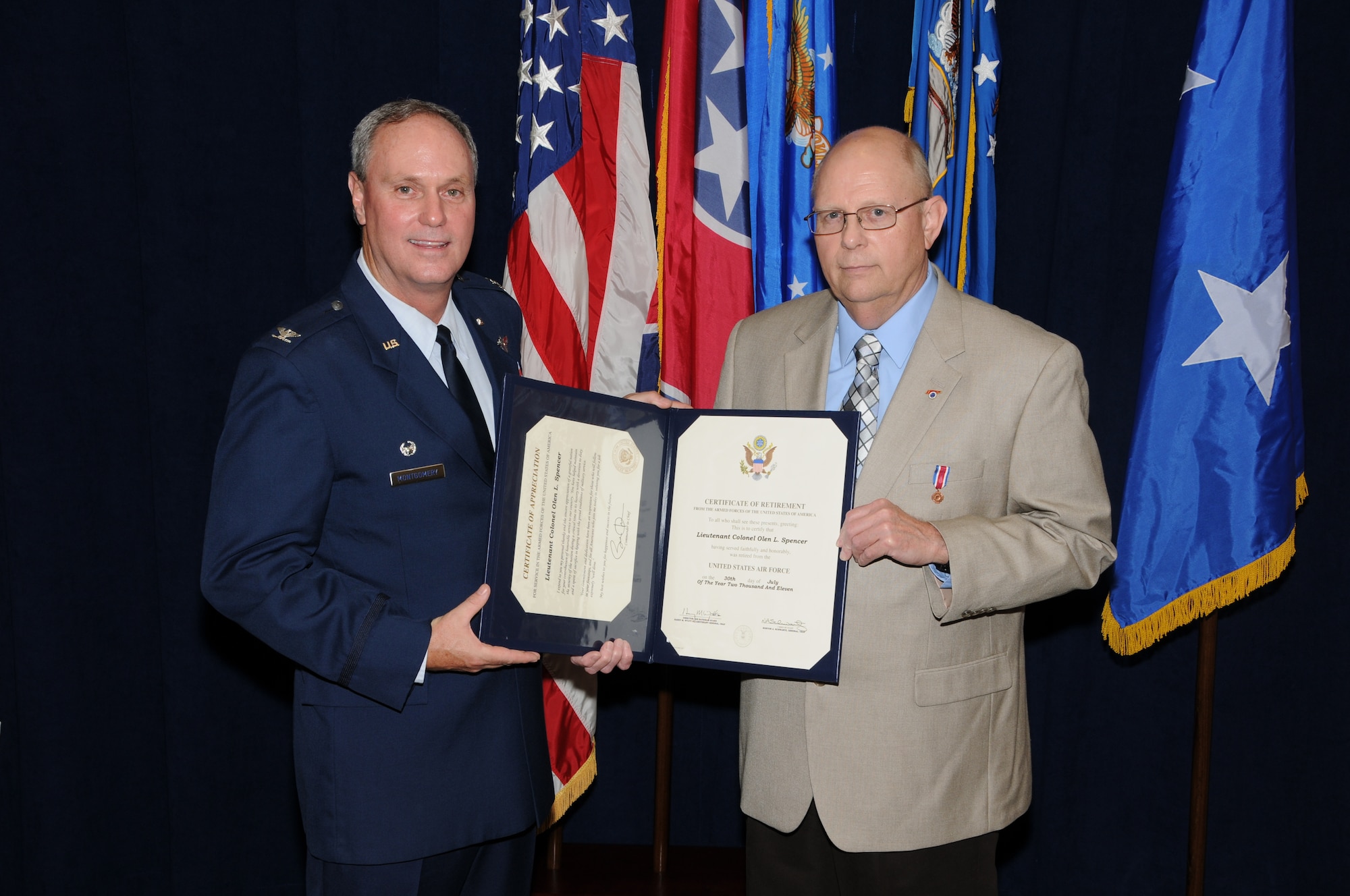 Colonel Harry D. Montgomery, 164th Airlift Wing Commander, presents the Certificate of Retirement to Lieutenant Colonel Lamar Spencer during Col Spencer's retirement ceremony.