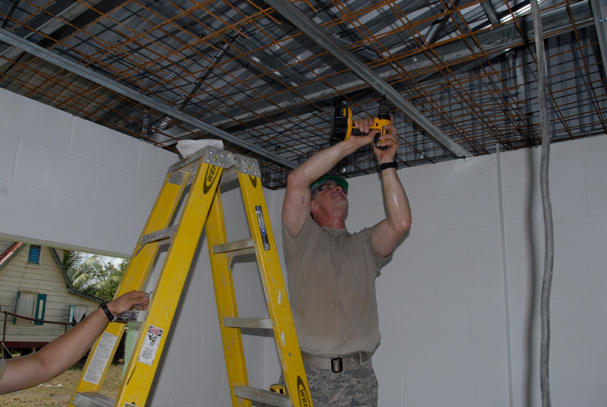 PARAMARIBO, SURINAME - Master Sgt. Mike Clausen, 1st Sgt. for the 114th Fighter Wing Civil Engineer Squadron, helps hang a piece of ridge brace at the Alkmaar Clinic being built in the Commewijne district here July 13, 2011.  The clinic is being built in support of the New Horizons 2011 exercise.   (Air Force Photo by Tech. Sgt. Quinton Young)(RELEASED) USAF