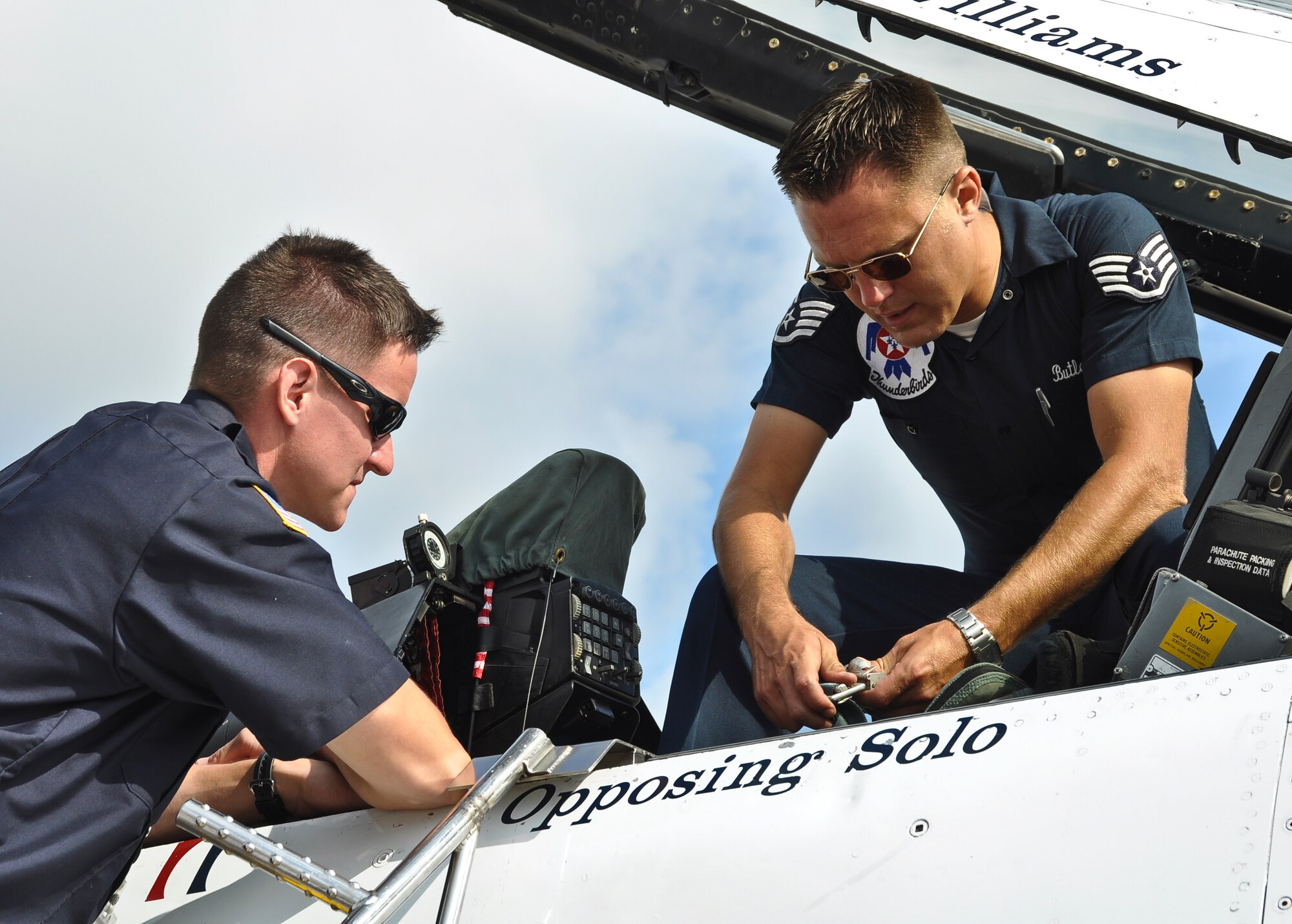 Air Force Staff Sgt. Brandon Gumm of the 128th Air Refueling Wing's fire department listens as Staff Sgt. Brad Butler, U.S. Air Force Thunderbird maintenance operation command, talks about the water retrieval methods of the aircraft’s pilot in the event of a mishap during the 2011 Milwaukee Air and Water Show.  The Thunderbirds are assigned to Nellis Air Force Base, Las Vegas, Nevada, and they perform 70 shows per year; the air demonstration team was officially established in 1953.  The Milwaukee Air and Water Show is a free event that took place at Milwaukee’s Bradford Beach on August 6 and 7.  (U.S. Air Force photo by Staff Sgt. Jeremy Wilson / Released)