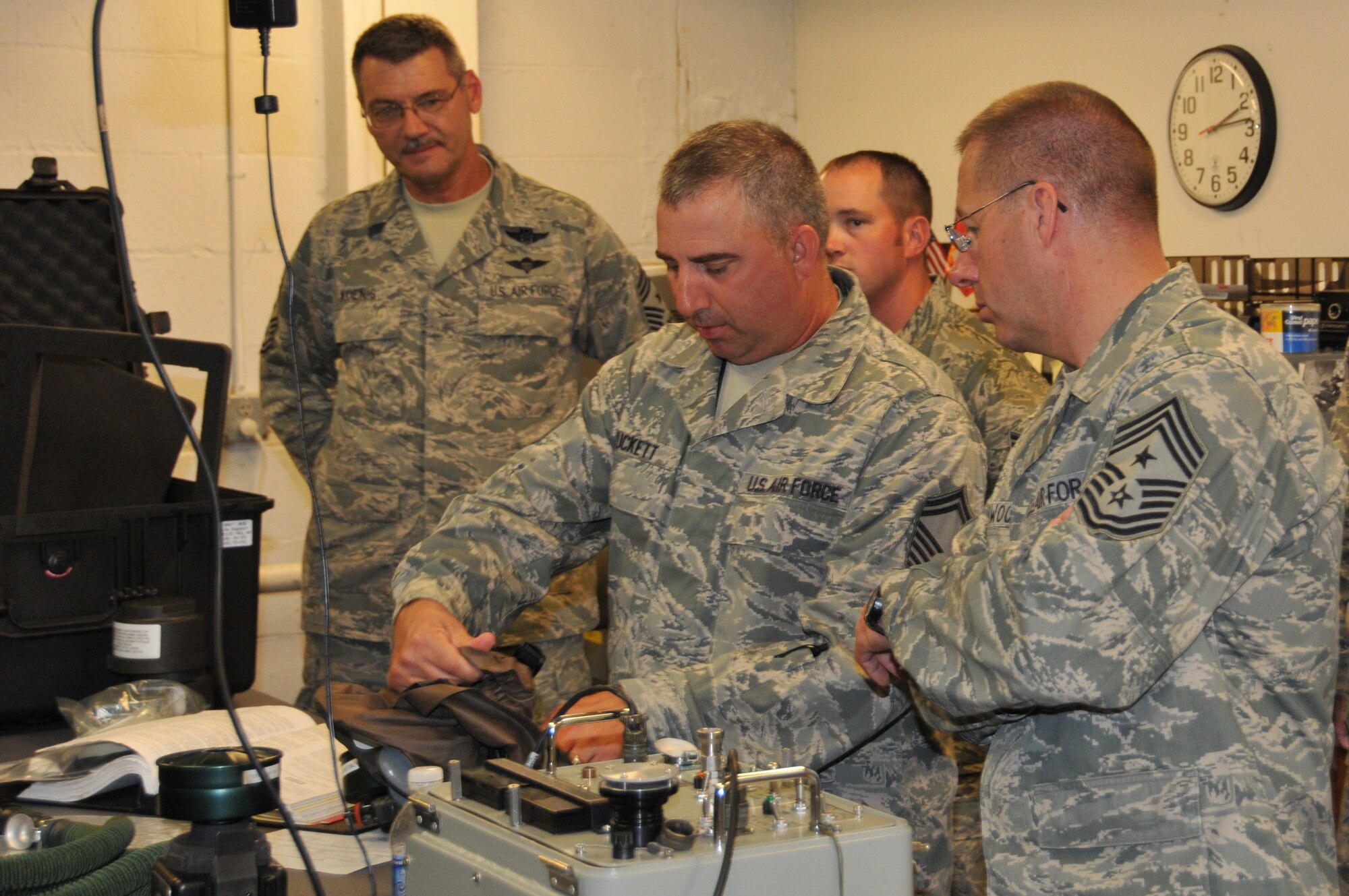 Chief Master Sgt. Mark Koenig (left), 934AW command chief, and Chief Master Sgt. Steven M. Larwood (right), 22AF command chief watch as Senior Master Sgt. Troy Puckett, 934 aircrew flight equipment explains equipment functions and servicing.  (Air Force photo/Tech. Sgt. Jim Loehr)