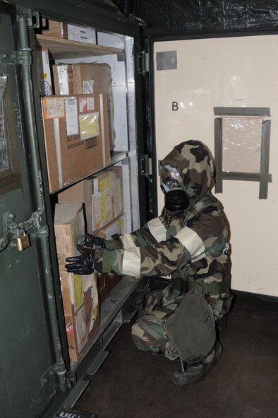 Tech. Sgt. Leanne Praska, with the 132nd Fighter Wing (132FW), Des Moines, Iowa Supply area, searches for an item in a storage bin in the Supply building of Volk Field, Wisconsin on June 22, 2011.  Sgt. Praska is dressed in Mission Oriented Protective Posture (MOPP) 4 during Operational Readiness Exercise, "Operation Lightning Bug".  (US Air Force photo/Staff Sgt. Linda E. Kephart)(Released)