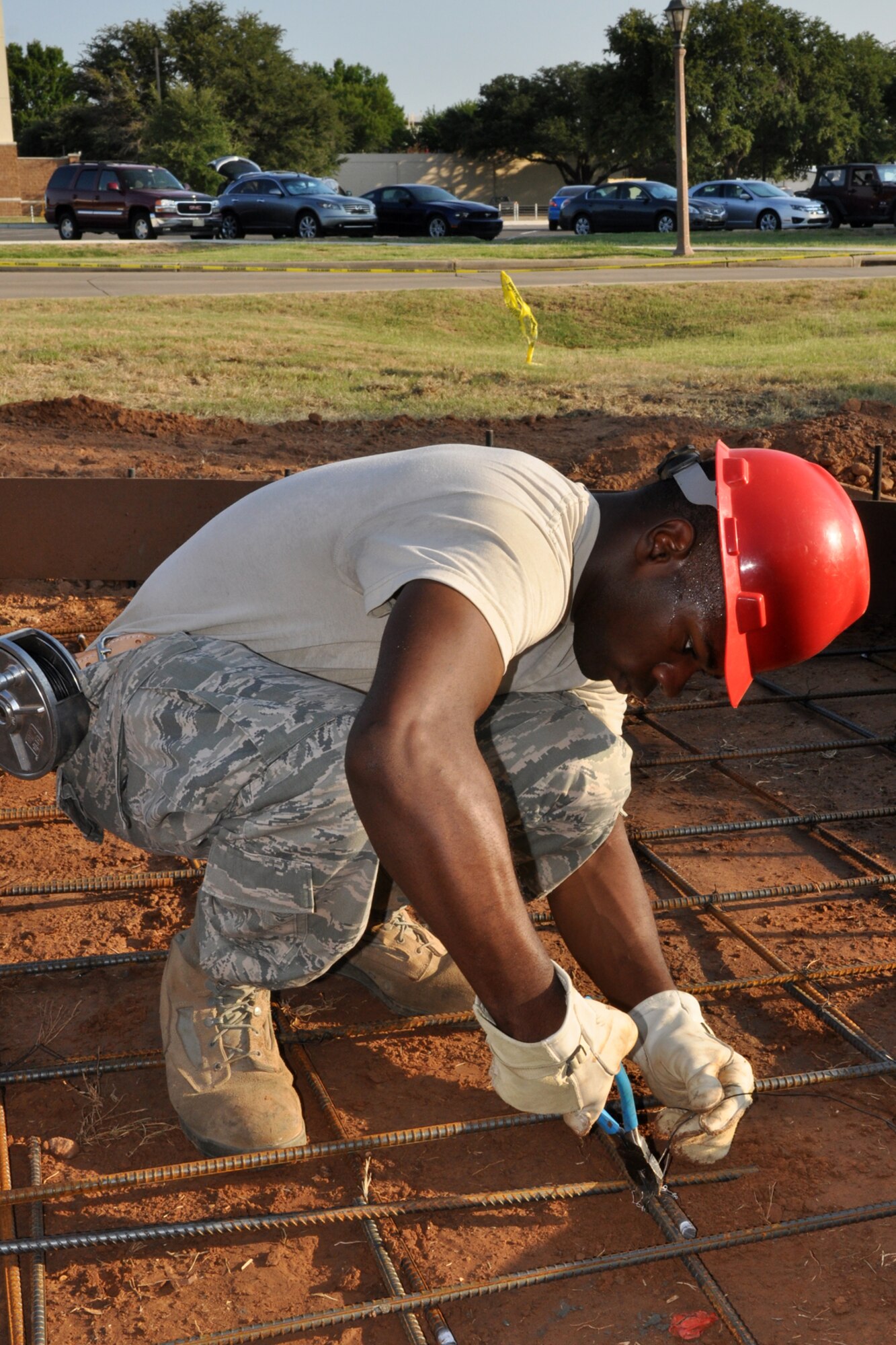 Senior Airman Cshamad Reed, a carpenter with the 307th RED HORSE Squadron ties rebar together on a construction project at Barksdale Air Force Base, La., Aug. 4, 2011. The Rapid Engineer Deployable Heavy Operations Repair Squadron Engineers (RED HORSE) Squadron was working on a construction project at the 93rd Bomb Squadron. (U.S. Air Force photo/Tech. Sgt. Jeff Walston) 