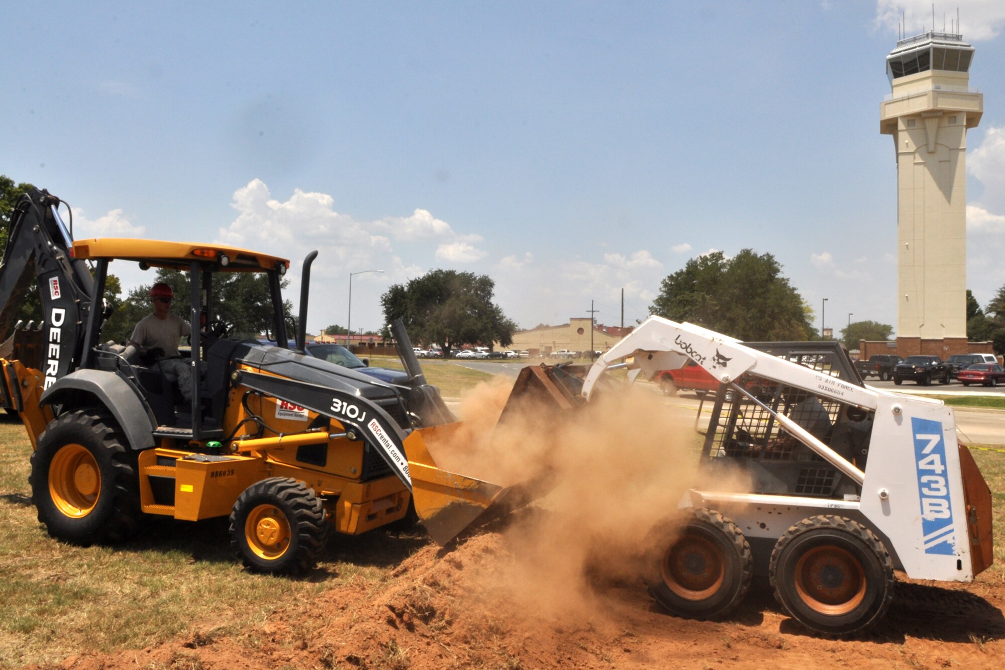 Tech. Sgt.  Joseph Lalizzi waits on his backhoe as Tech. Sgt. Dexter Hodge dumps excavated dirt in the bucket for transfer to a dump truck at Barksdale Air Force Base, La., Aug. 1, 2011. Lalizzi and Hodge are heavy equipment operators assigned to the 307th RED HORSE Squadron at Barksdale. The Rapid Engineer Deployable Heavy Operations Repair Squadron Engineers (RED HORSE) Squadron was working on a construction project at the 93rd Bomb Squadron. (U.S. Air Force photo/Tech. Sgt. Jeff Walston) 
