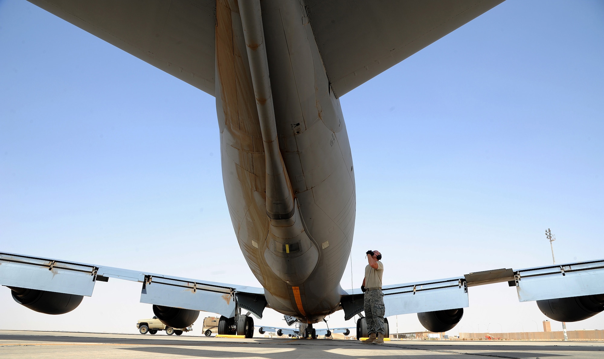 Air Force Senior Airman David Manning, 340th Expeditionary Aircraft Refueling Squadron jet engine mechanic, looks over the KC-135 Stratotanker while talking to other maintenance crew members during a pre-flight inspection in Southwest Asia. Good communication between crew members helps speed up the aircraft launch. (U.S. Air Force photo by Senior Airman Tristin English)