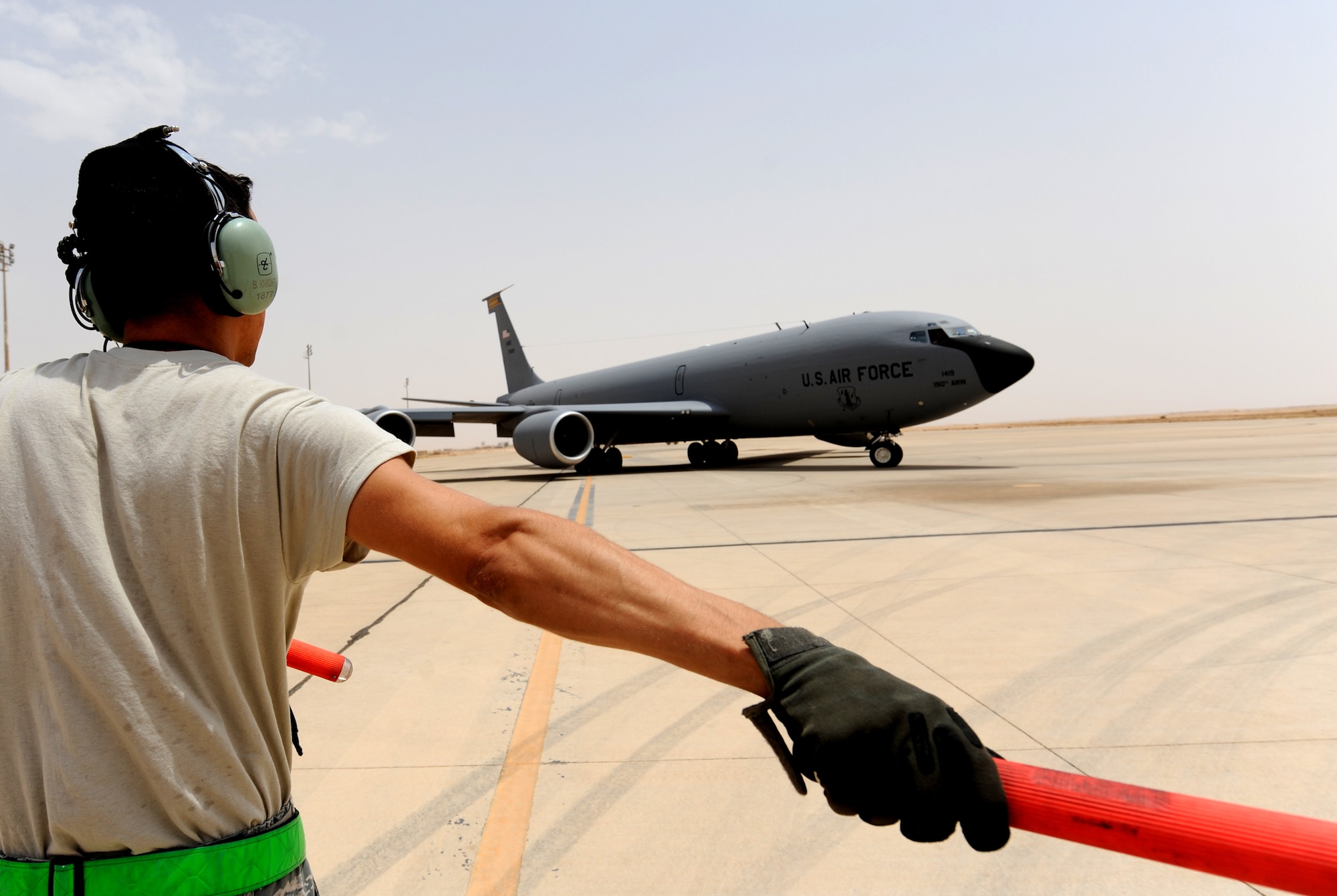 Air Force Tech. Sgt. Brian Knight, 340th Expeditionary Aircraft Refueling Squadron environmental and electrical specialist, gives directions to a KC-135 Stratotanker for take off in Southwest Asia. Marshaling the aircraft to the runway is the final step in the pre-flight process. (U.S. Air Force photo by Senior Airman Tristin English)