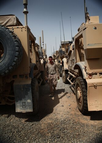 A Marine with the Motor and Transportation section, 1st Battalion, 6th Marine Regiment, makes his way through the motor pool here, Aug. 8. The Marines of Motor T are responsible for resupply operations in the area, as well as the maintenance and upkeep of all vehicles within the battalion.