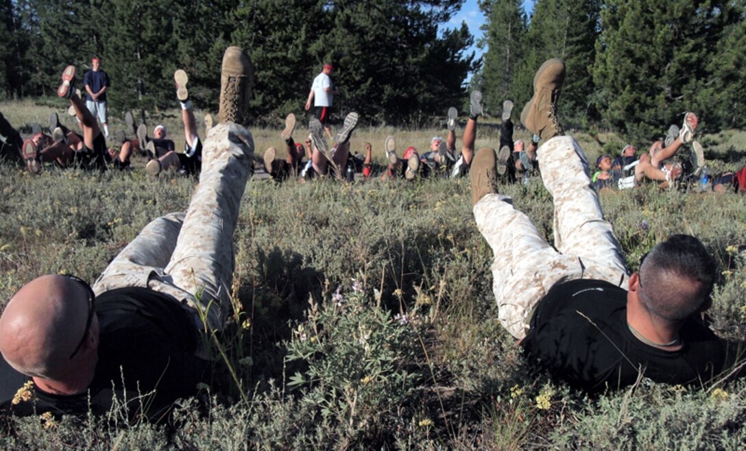 Command Officer Maj. Jeffrey H. Buffa, of Recruiting Station Salt Lake City, 12th Marine Corps District, and Gunnery Sgt. Shawn Pryzgoda, the supply chief with RS Salt Lake City, lead 54 Highland High School football players from Pocatello, Idaho, in a daily warm up routine during Highland's first high altitude training camp in Island Springs, Idaho, on Aug. 9.