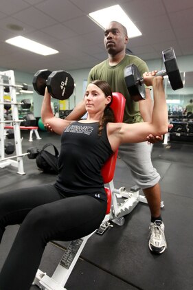 First Lieutenant Jennifer Silvers, the Marine Fighter Attack Squadron 122 material control officer, does chest presses with the help of a fellow Marine at the Air Station Fitness Center, Aug. 8. Silvers motivates her Marines by mentally and physically challenging herself and expecting her Marines to follow her high standards.