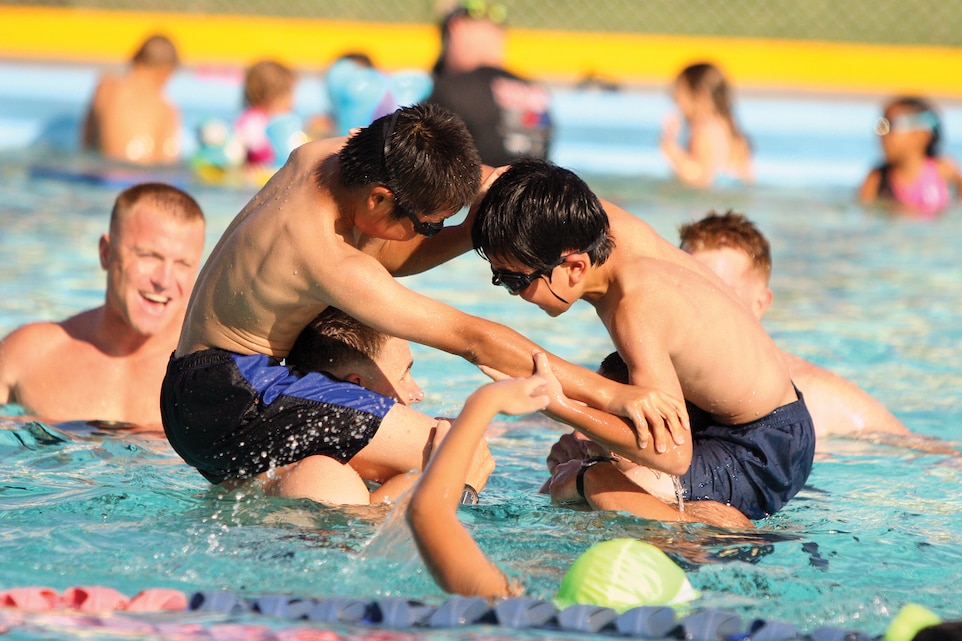 Students from Oshima district play water games with Marines at a pool party on Camp Foster held as part of a four-day cultural exchange program which took place Aug. 6-9.