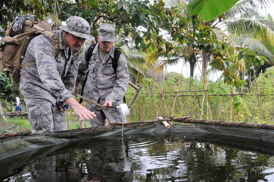 Cambodia -- Capt. Wes Walker and Tech. Sgt. Russ Thomas examine a water container for mosquitoes associated with malaria and dengue in a rural part of Cambodia during Operation PACIFIC ANGEL 11-1 Aug. 6, 2011. According to the Centers for Disease Control and Prevention, Cambodia had 57, 232 reported cases of malaria from 2000-2005; cases climbed to 64,595 cases in 2009. Captain Walker, an entomologist, and Sergeant Thomas, a public health technician, are both assigned to Kadena Air Base, Japan. (U.S. Air Force photo/Staff Sgt. Christopher Boitz)