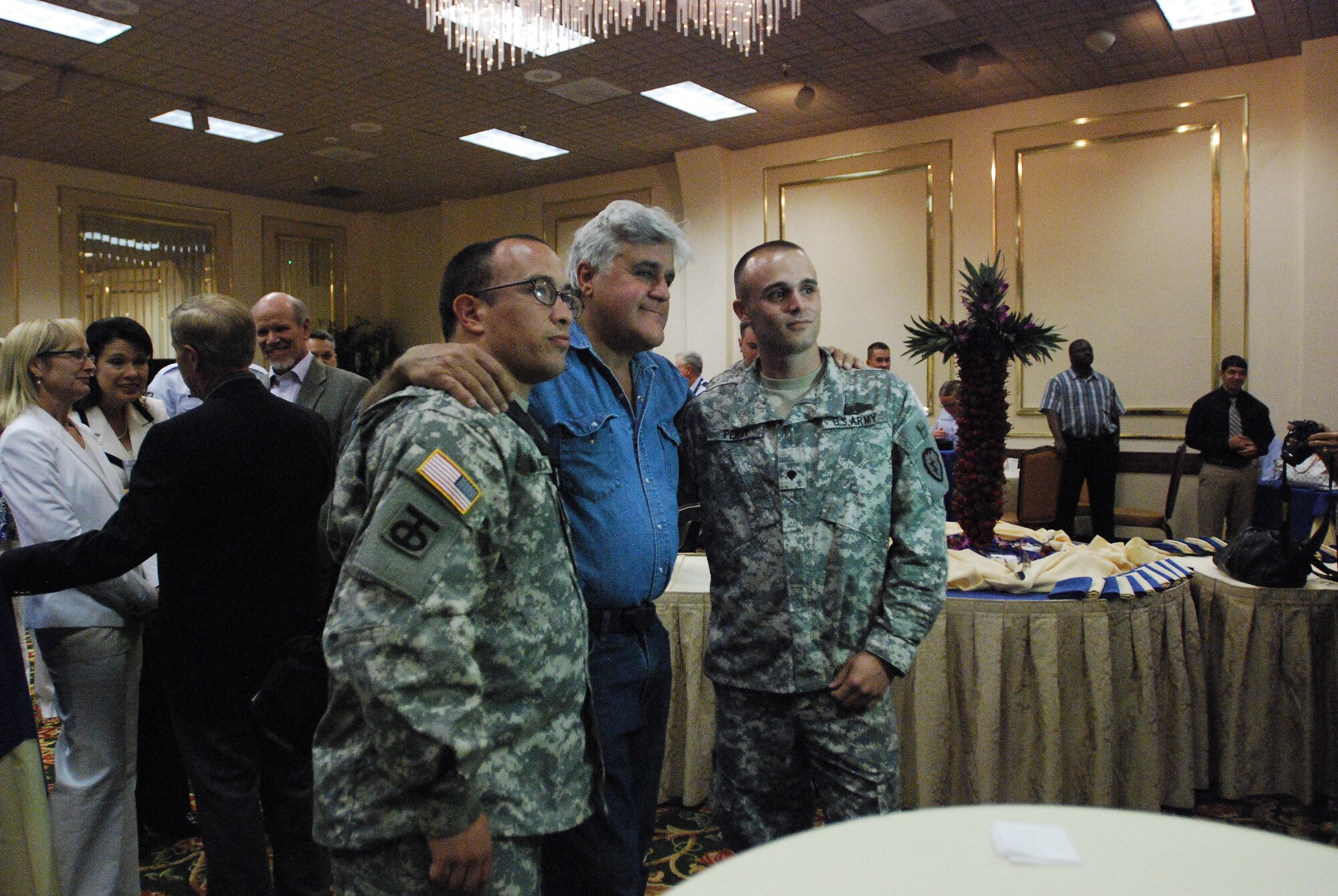Comedian and TV host, Jay Leno, poses for a group photo with two wounded warriors from Brooks Army Medical Center, Army Pfc. Juan Antonio Garcia and Spc. Kyle Perry, Aug. 6, 2011, at the Kelly Field Club next to Lackland Air Force Base, Texas. Leno met with service members, local community leaders and other guests at a private reception ceremony. The term, wounded warrior, is commonly used to refer to military members who've been seriously injured in combat while deployed to war zones such as Iraq and Afghanistan among others. (U.S. Air Force photo/Senior Airman Brian McGloin) 