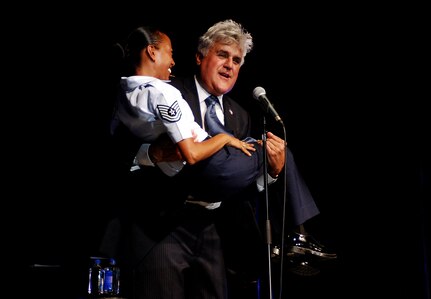 Comedian and TV host, Jay Leno, shows off his strength and spontaneous personality by picking up 4-foot, 10-inch tall, Tech. Sgt. Hilary Reyes, mistress of ceremonies, minutes after concluding an hour-long comedic performance, Aug. 6, 2011, at Lackland Air Force Base, Texas.  More than 2,000 people attended the event officially hosted by the 433rd Airlift Wing and sponsored by the Air Force Reserve Command's recruiting program, “Get 1 Now.” (U.S. Air Force photo/Senior Airman Brian McGloin)