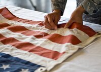 Senior Airman Francine Leyva, 28th Aircraft Maintenance Squadron debriefer, puts her stitch in the American flag during a special 9/11 flag stitching event at Ellsworth Air Force Base, S.D., Aug. 4, 2011. More than 150 Airmen and family members had the privilege to put a stitch in the flag. (U.S. Air Force photo/Airman Alystria Maurer/Released)