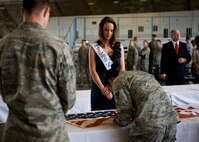 Anna Simpson, Miss South Dakota, watches as an Airman puts a stitch in an American flag during a special 9/11 flag stitching event at Ellsworth Air Force Base, S.D., Aug.  4, 2011. Miss South Dakota is traveling around the state providing opportunities for men and women to sew a stitch into a patch for the National 9/11 Flag. (U.S. Air Force photo/Airman Alystria Maurer/Released)