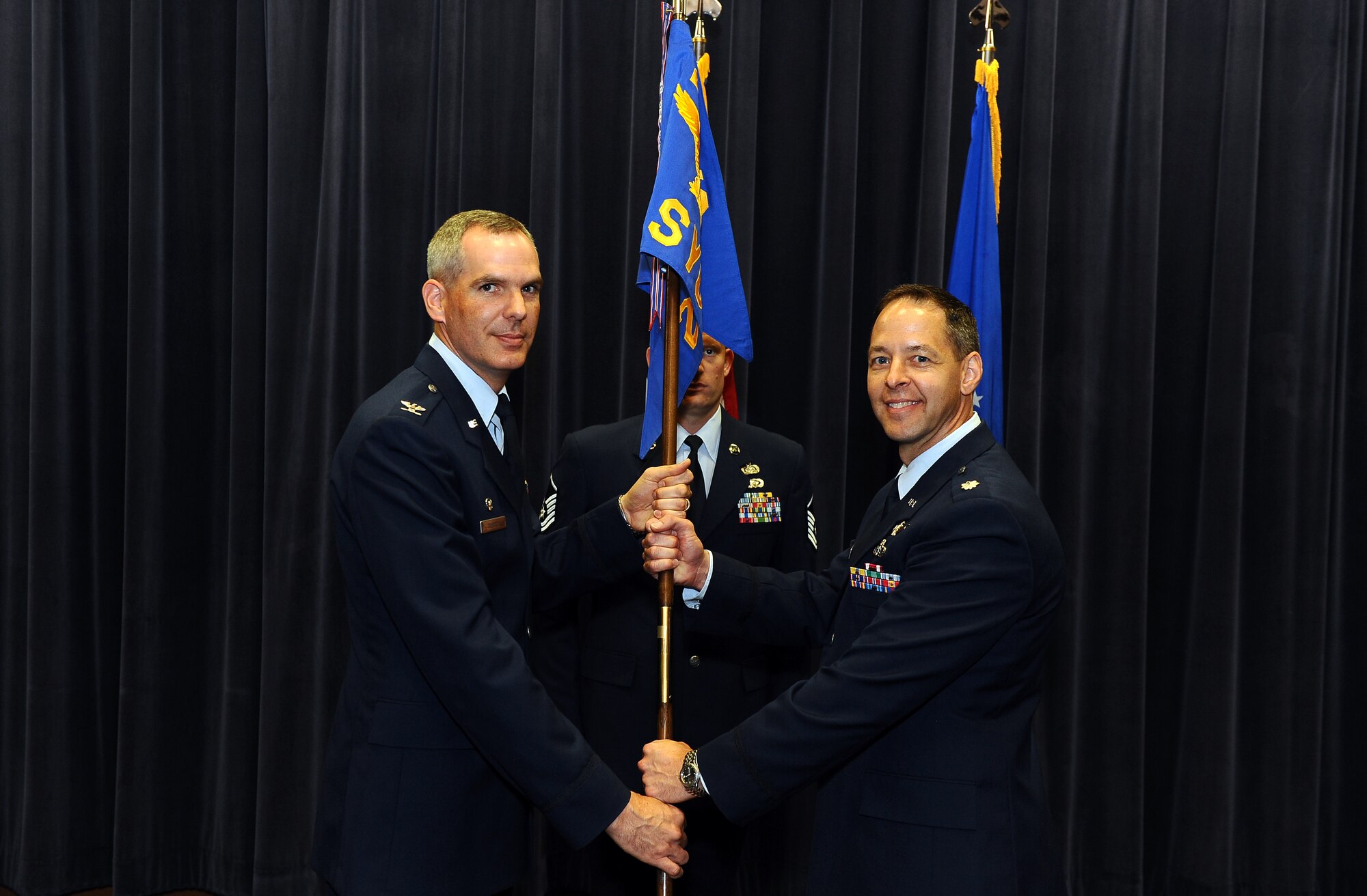 U.S. Air Force Col. Steven P. DeSordi, 2d Weather Group commander, passes the 2d Systems Operations Squadron guidon to incoming commander U.S. Air Force Lt. Col. Michael L. Gauthier, during a change of command ceremony inside the Air Force Weather Agency’s auditorium at Offutt Air Force Base, Neb., July 22. (U.S. Air Force Photo by Josh Plueger)