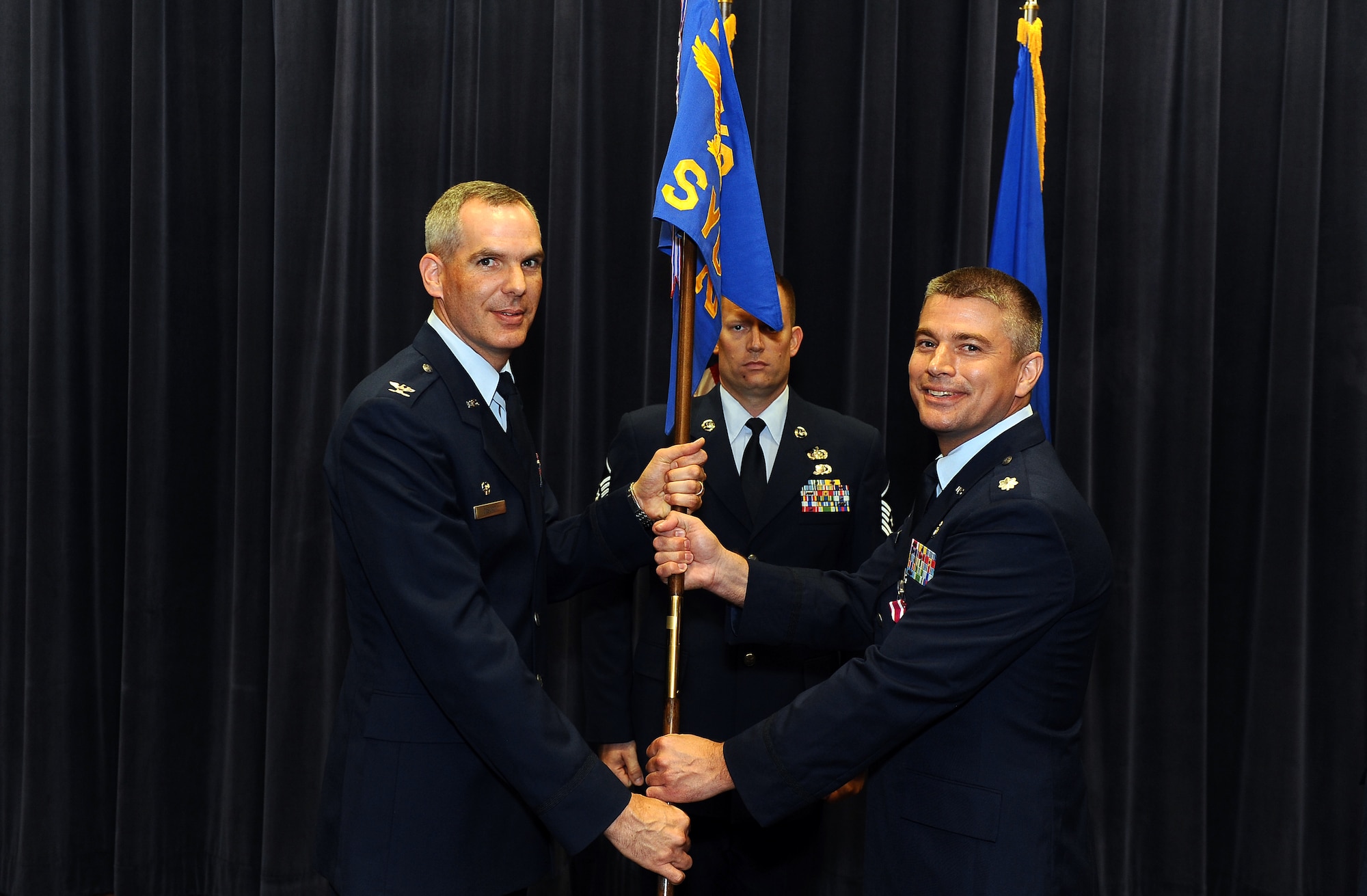 U.S. Air Force Lt. Col. Jeffrey D. Shull, 2d Systems Operations Squadron, relinquishes command and passes the guidon to U.S. Air Force Col. Steven P. DeSordi, 2d Weather Group commander, during a change of command ceremony inside the Air Force Weather Agency’s auditorium at Offutt Air Force Base, Neb., July 22. (U.S. Air Force Photo by Josh Plueger)
