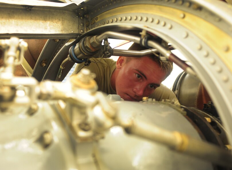 U.S. Air Force Airman 1st Class Caleb Cox, 23rd Component Maintenance Squadron aerospace propulsion apprentice, assists with installing a generator into a T-56 engine of an HC-130 Combat King at Moody Air Force Base, Ga., Aug. 8, 2011. Cox has been at Moody for a month, and completed 71 days of technical training that covered the removing, installing and repairing of aircraft engines. (U.S. Air Force photo by Senior Airman Stephanie Mancha/Released)