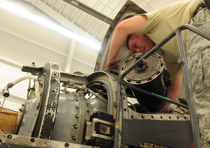 U.S. Air Force Staff Sgt. Jonathan Ruszler, 23rd Component Maintenance Squadron aerospace propulsion craftsman, reinstalls the generator back into the T-56 engine of an HC-130 Combat King at Moody Air Force Base, Ga., Aug. 8, 2011. Ruszler helped provide on-the-job training to seven Airmen that are currently in upgrade training. (U.S. Air Force photo by Senior Airman Stephanie Mancha/Released)