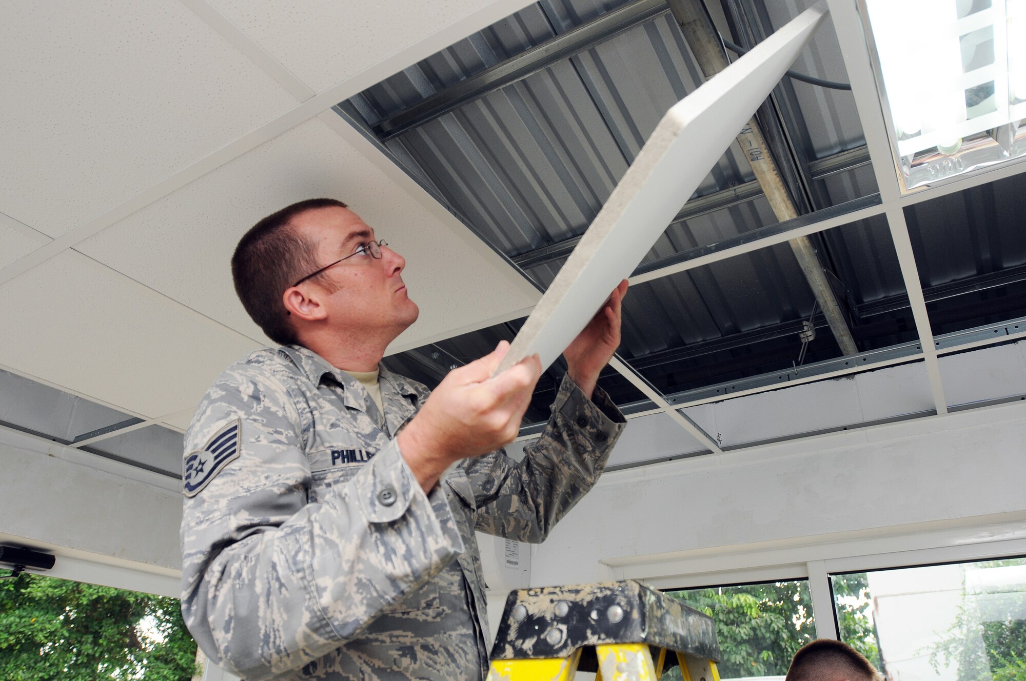 COMMEWIJNE, SURINAME - Staff Sgt. Tony Phillips, 445th Civil Engineer Squadron, places a ceiling tile in the rafter of the clinic in the Surinamese district of Commewijne, July 27, 2011, as part of the New Horizons training exercise. New Horizons is a cooperative humanitarian training exercise between the Suriname government and the United States Southern Command with the goal of helping to improve the quality of life for the people of Suriname. (Photo by Staff Sgt. Theanne Tangen)