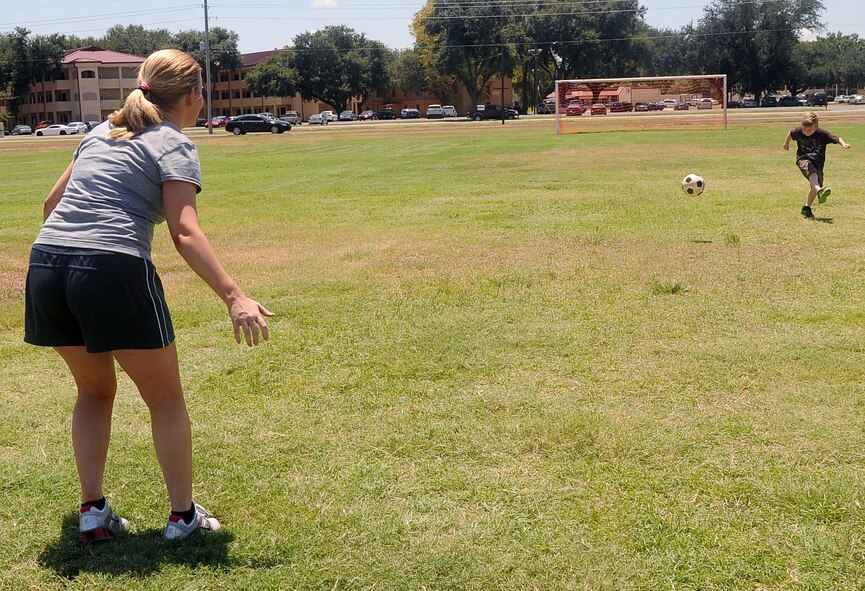 Camilla Craig, wife of retired National Guard Command Sgt. Maj. Kelly Craig, prepares to stop the soccer ball that her son Gage Daniel kicked at the Barksdale Air Force Base Fitness Center field, Aug 8. Despite the Louisiana heat, Craig and her son enjoy the outside summer activities before school starts. (U.S. Air Force photo by Senior Airman Amber Ashcraft) (RELEASED)