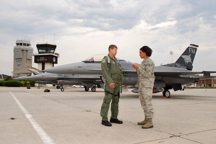 Airman 1st Class Chelsea Smith from the Dobbins Air Reserve Base Public Affairs office, interviews Lt. Col. Dag Grantham from the 93rd Fighter Squadron, Homestead Air Reserve Base, Fla., on the Dobbins ARB flight line, Aug 4.  Pilots from the 93rd Fighter Squadron flew 14 of their F-16C Fighting Falcons here as a precautionary measure to avoid possible damage from tropical storm Emily, currently brewing in the Atlantic Ocean.  (U.S. Air Force photo/ Brad Fallin)