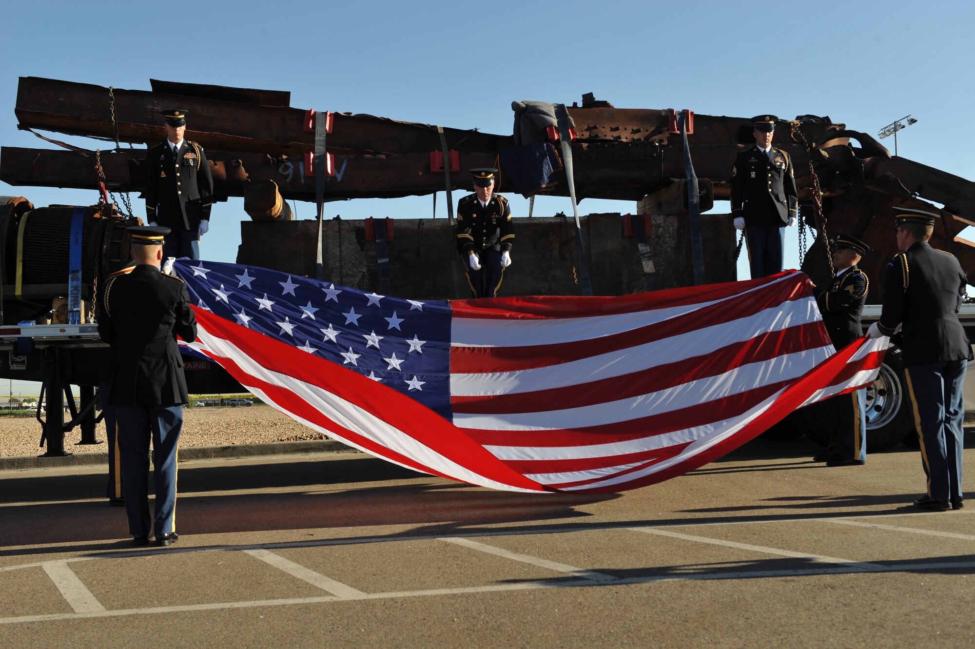 BUCKLEY AIR FORCE BASE, Colo. -- Honor guardsmen of the Colorado Army National Guard remove a flag that covered pieces of the World Trade Center Aug. 8, 2011. The pieces, shipped here from the Port Authority of New York and New Jersey, stopped overnight at Buckley AFB en route to downtown Denver. (U.S. Air Force photo by Airman 1st Class Phillip Houk)