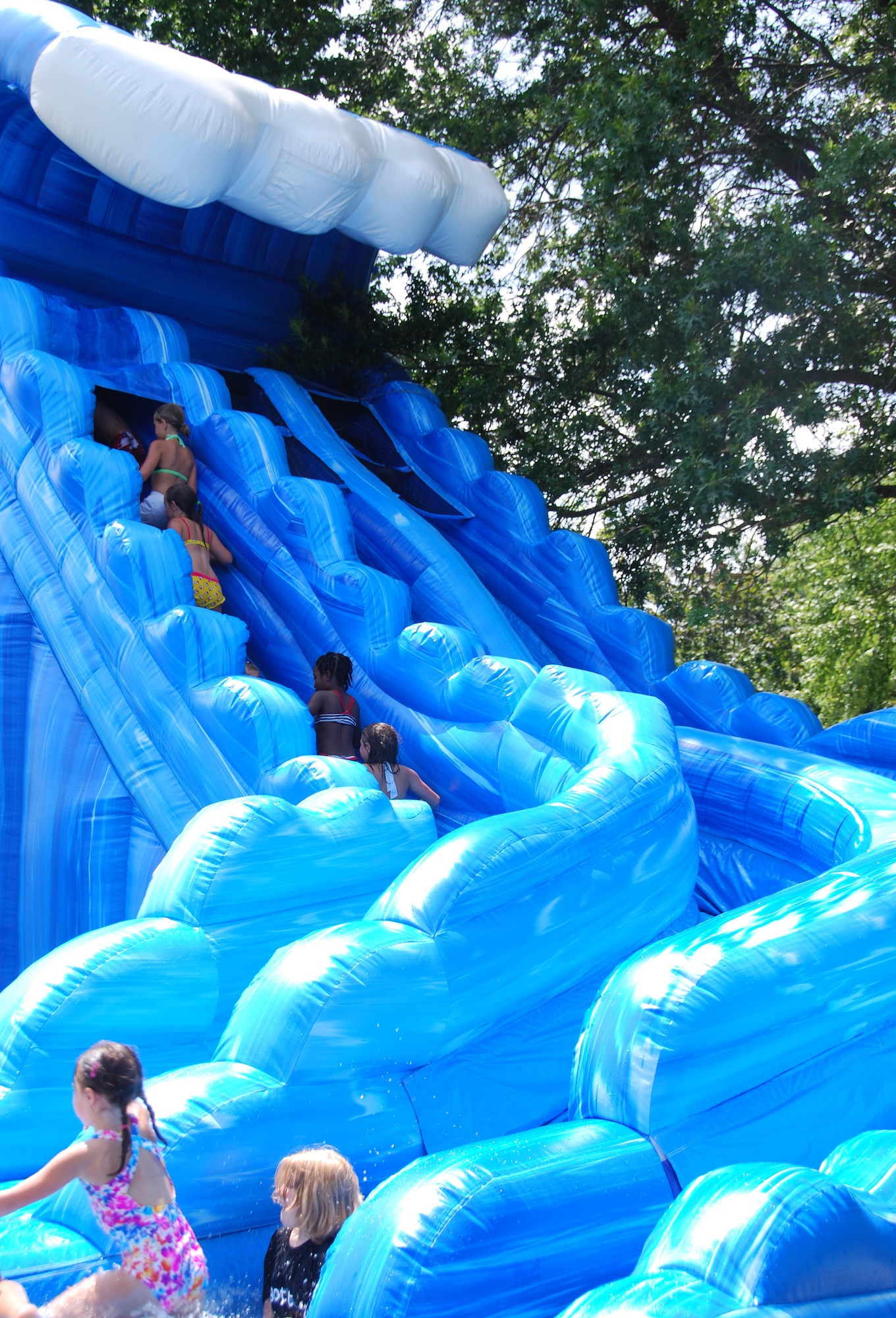 An inflatable water slide was one of the star attractions for children at the 512th Airlift Wing biennial picnic Aug. 6 at Eagle?s Nest. More than 2,000 people attended the event that featured live entertainment, a Kids Zone, and hamburgers, hot dogs and ice cream. (U.S. Air Force photo by Senior Master Sgt. Ron Toomey)