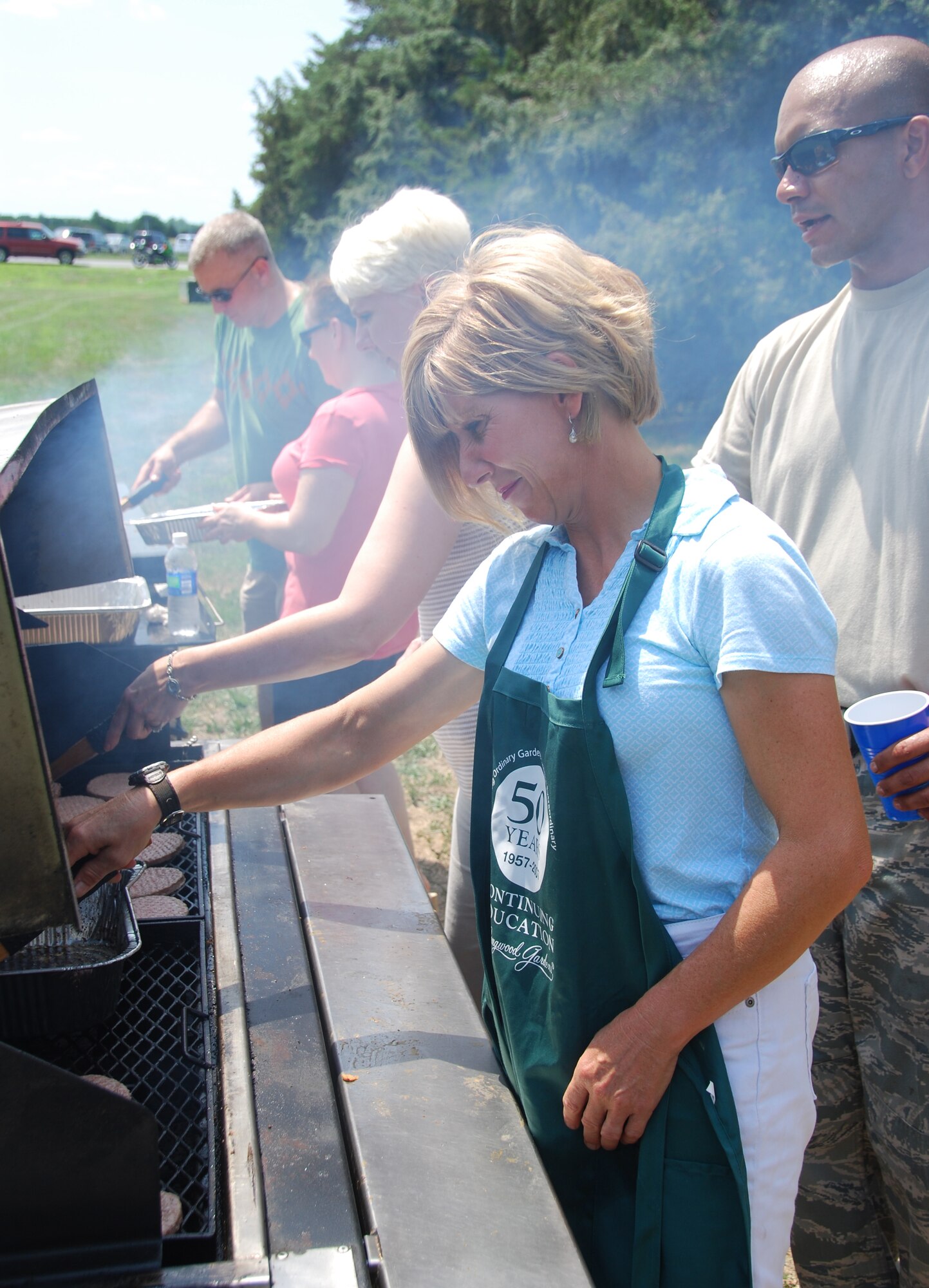 Senior Airman Christine King, 712th Aircraft Maintenance Squadron, volunteered to cook food for the 512th Airlift Wing biennial picnic Aug. 6 at Eagle?s Nest. More than 2,000 people attended the event that featured live entertainment, a Kids Zone, and a menu of hamburgers, hot dogs and ice cream. (U.S. Air Force photo by Senior Master Sgt. Ron Toomey)