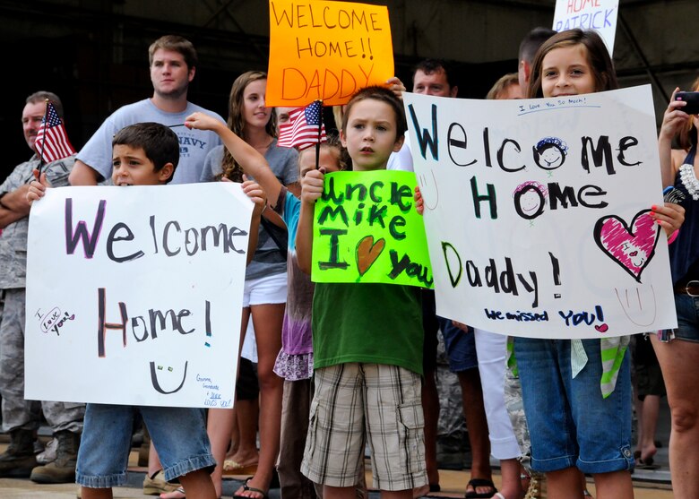 Children hold up signs as Air Force Reservists make their way to greet their family after a deployment to Southwest Asia, Aug. 7.  More than 25 Airmen were welcomed back home at a homecoming gathering at Duke Field.  (U.S. Air Force photo/Tech. Sgt. Cheryl Foster)