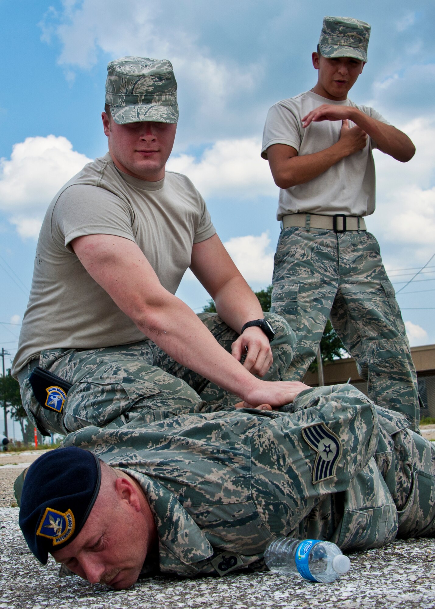 Airman 1st Class Jacob Holsclaw, from the 919 Security Forces Squadron, secures Staff Sgt. Eric Beane on the ground while Airman 1st Class Adam Munoz stands overwatch during flightline entry control procedures training at Duke Field, Aug. 6.  (U.S. Air Force photo/Tech Sgt. Samuel King Jr.)(U.S. Air Force photo/Tech Sgt. Samuel King Jr.)