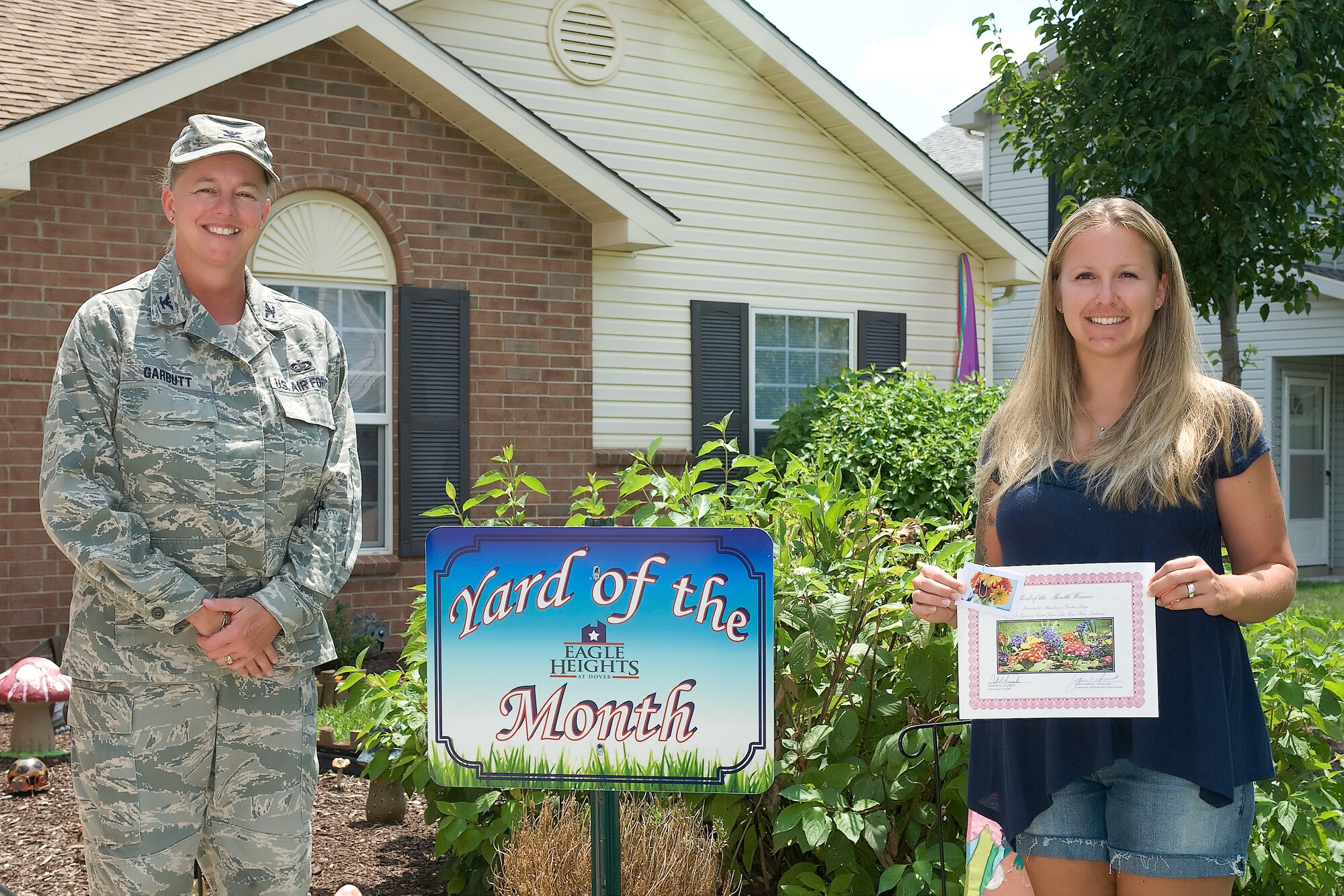 Col. Joan Garbutt (left), the commander of the 436th Mission Support Group, presents Kristin King, wife of Staff Sgt. Brandon King, with the Yard of the Month – July Award for the Orioles Cave neighborhood Aug. 1, 2011 at Dover Air Force Base, Del.  (U.S. Air Force photo by Steve Kotecki)