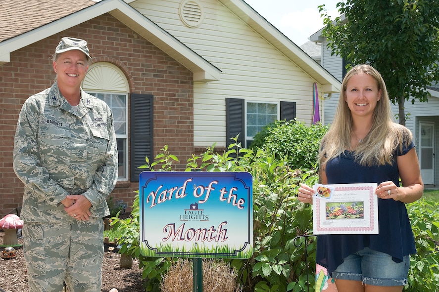 Col. Joan Garbutt (left), the commander of the 436th Mission Support Group, presents Kristin King, wife of Staff Sgt. Brandon King, with the Yard of the Month – July Award for the Orioles Cave neighborhood Aug. 1, 2011 at Dover Air Force Base, Del.  (U.S. Air Force photo by Steve Kotecki)