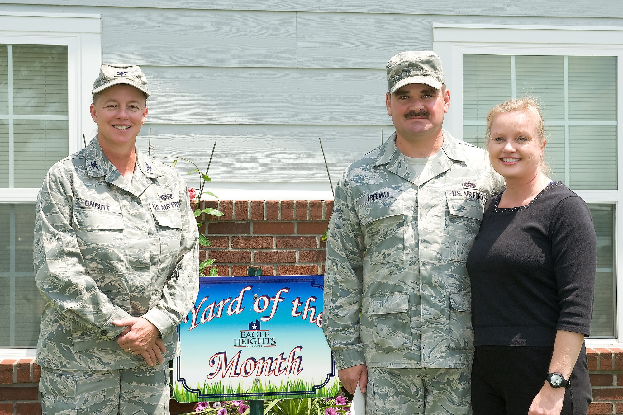 Col. Joan Garbutt (left), the commander of the 436th Mission Support Group, presents Tech. Sgt. Frank Freeman and his wife Maria with the Yard of the Month – July Award for the Blue Heron Breeze neighborhood Aug. 1, 2011, at Dover Air Force Base, Del. (U.S. Air Force photo by Steve Kotecki)