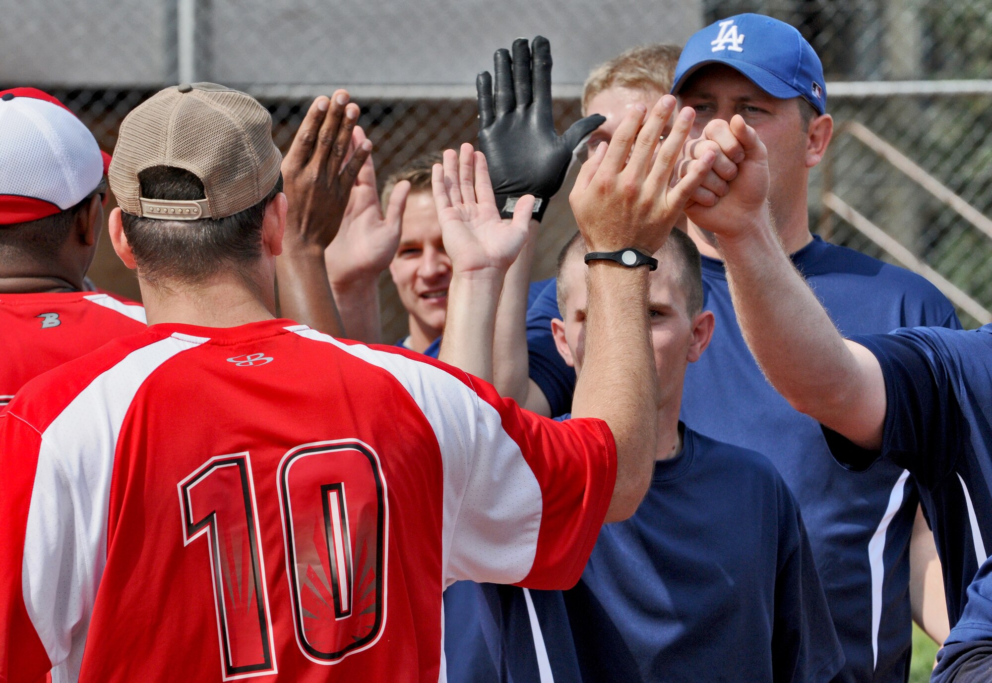 SPANGDAHLEM AIR BASE, Germany – Members from the 606th Air Control Squadron Galley Warriors, blue, and Royal Air Force Croughton Cougars, red, give each other good game high fives during a U.S. Air Forces in Europe Small Units Softball Tournament game against the 606th Air Control Squadron Galley Warriors here Aug. 4. The 726th Air Mobility Squadron won the tournament or out the seven teams from across Europe that competed. (U.S. Air Force photo/Senior Airman Nick Wilson)