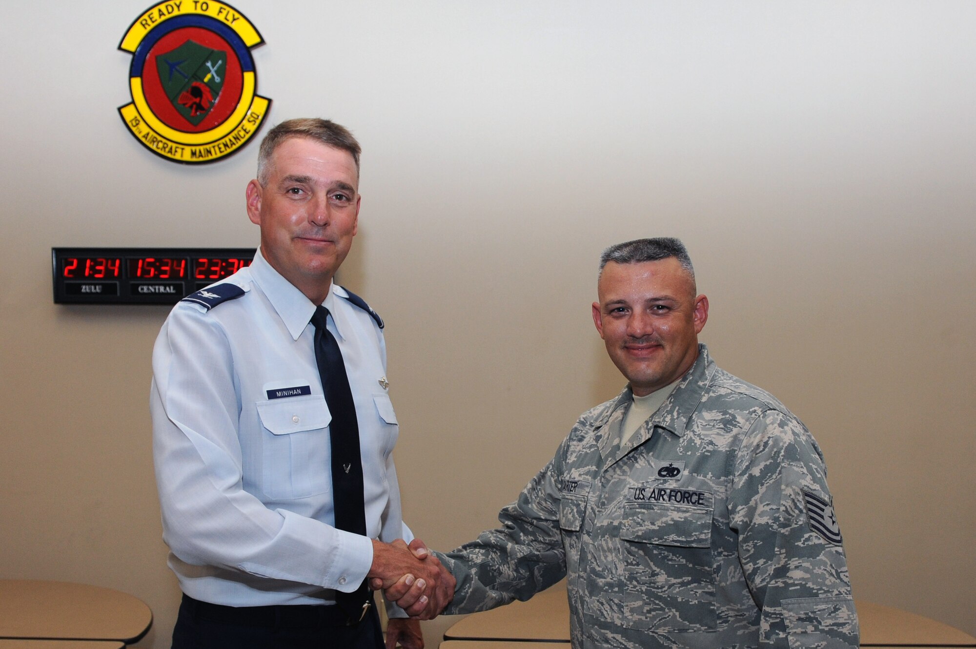 Col. Mike Minihan, 19th Airlift Wing commander, presents his commander’s coin Aug. 1, 2011, to Tech. Sgt. Dwight Carter, a 19th Aircraft Maintenance Squadron aircraft maintenance unit consolidated tool kit section chief, at Little Rock Air Force Base, Ark. Carter was the critical driving factor in the 19th AMXS tool section completing their flight line move five days ahead of schedule. (U.S. Air Force photo by Airman 1st Class Rusty Frank)