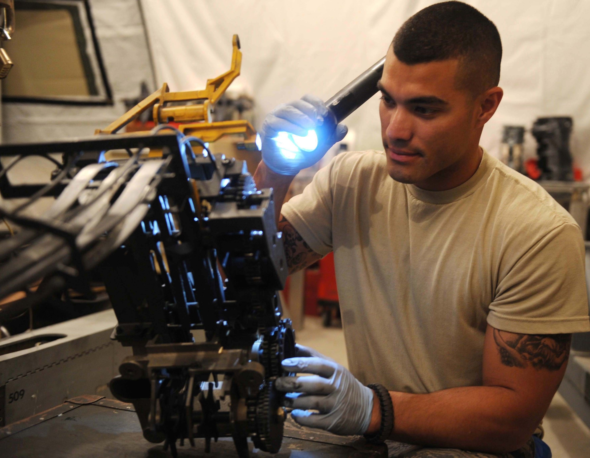Senior Airman Edgar Pardo, 380th Expeditionary Aircraft Maintenance Squadron, aircraft armament system journeyman, inspects part of the M61A1 20-millimeter gatling gun system Aug. 4, 2011, at the 380th Air Expeditionary Wing in Southwest Asia. Pardo is one of eight Airmen in the F-15 Eagle armament shop. (U.S. Air Force photo/Master Sgt. Chance Babin)