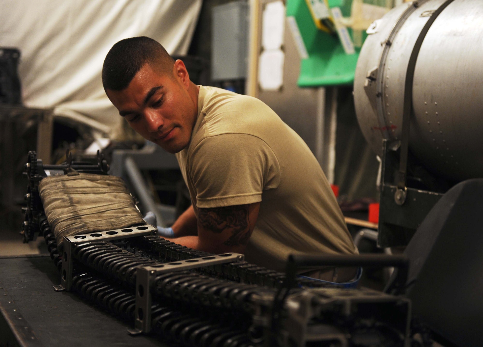 Senior Airman Edgar Pardo, 380th Expeditionary Aircraft Maintenance Squadron, aircraft armament system journeyman, runs a dummy round through a feed shoot of the M61A1 20-millimeter gatling gun system Aug. 4, 2011. Pardo is one of eight Airmen in the F-15 Eagle armament shop at the 380th Air Expeditionary Wing in Southwest Asia. (U.S. Air Force photo/Master Sgt. Chance Babin)